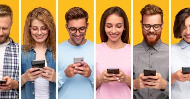 Mehrere junge Leute mit Smartphones vor gelbem Hintergrund